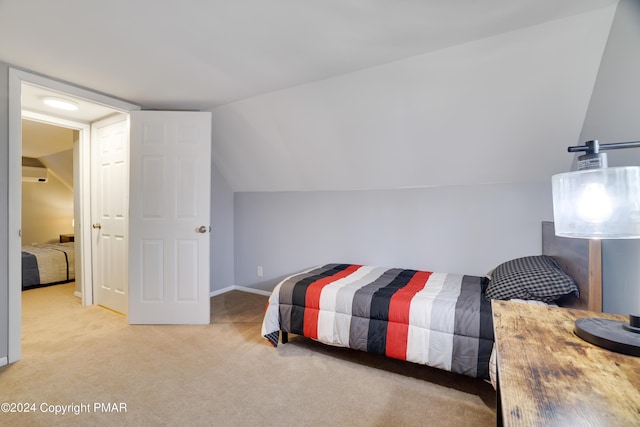 bedroom with light carpet, baseboards, and vaulted ceiling