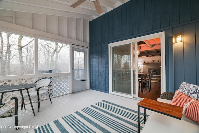 sunroom / solarium featuring vaulted ceiling with beams and ceiling fan