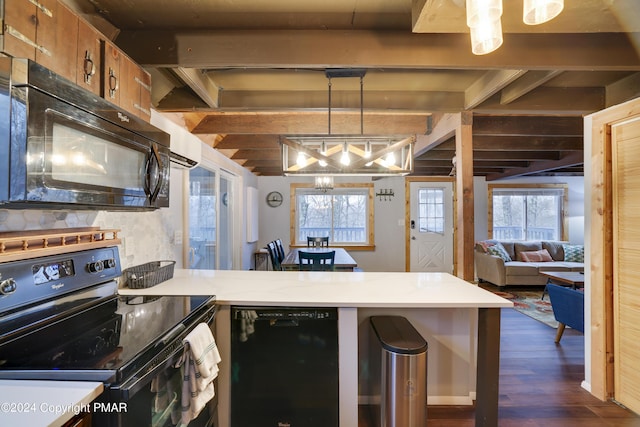 kitchen with dark wood finished floors, light countertops, brown cabinetry, a peninsula, and black appliances