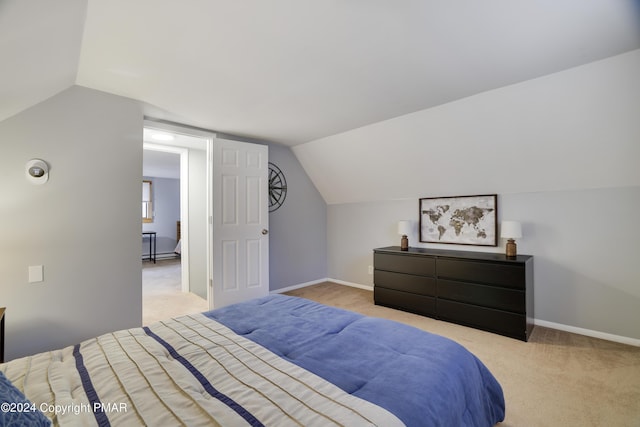 carpeted bedroom featuring vaulted ceiling and baseboards