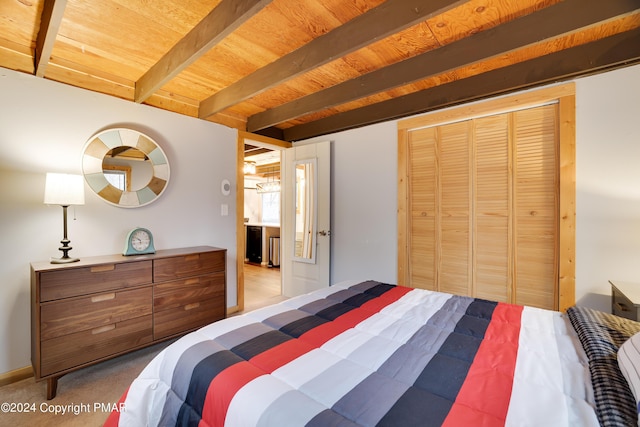 carpeted bedroom with wood ceiling, a closet, and beam ceiling