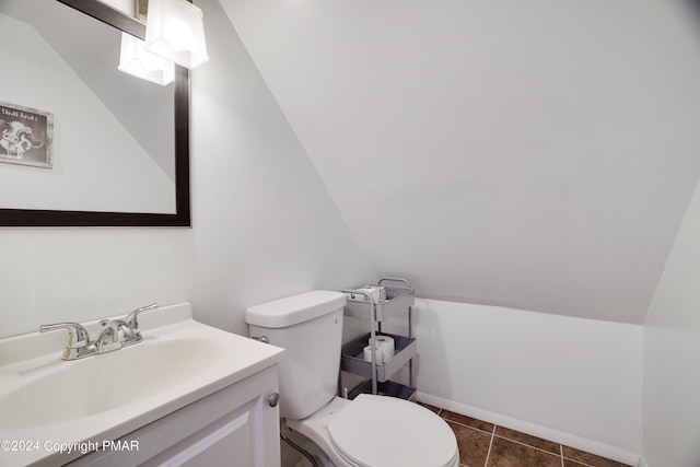 bathroom featuring vaulted ceiling, vanity, toilet, and tile patterned floors