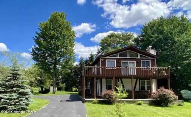 view of front of property featuring a wooden deck and a front yard