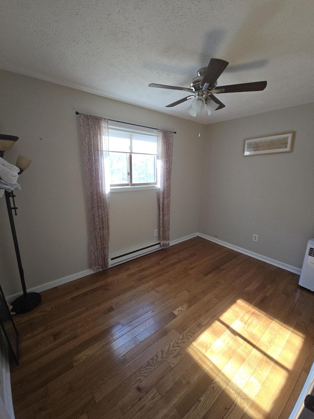 empty room featuring a baseboard radiator, a ceiling fan, wood finished floors, baseboards, and a textured ceiling