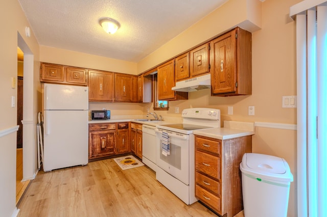 205 W Williams Ct, Stroudsburg, PA 18360 - kitchen with white appliances, under cabinet range hood, brown cabinetry, and a textured ceiling