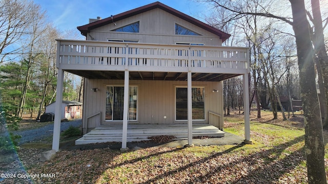 back of house with an outbuilding and a wooden deck