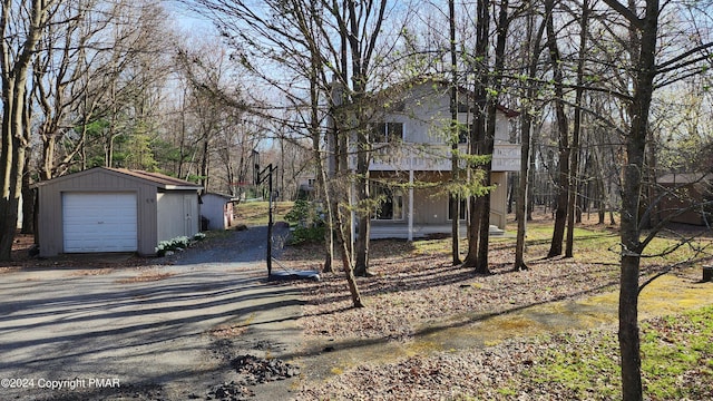 exterior space featuring an outdoor structure, driveway, and a detached garage