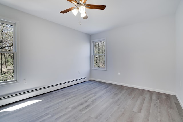 empty room with a ceiling fan, light wood-style floors, baseboards, and a baseboard radiator