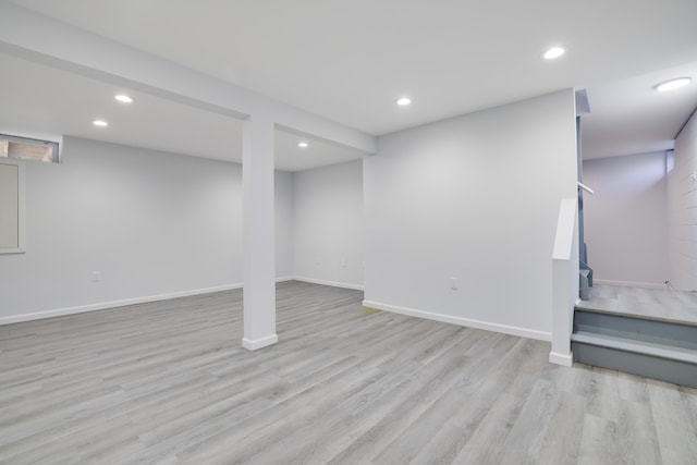 finished basement with stairway, baseboards, light wood-type flooring, and recessed lighting