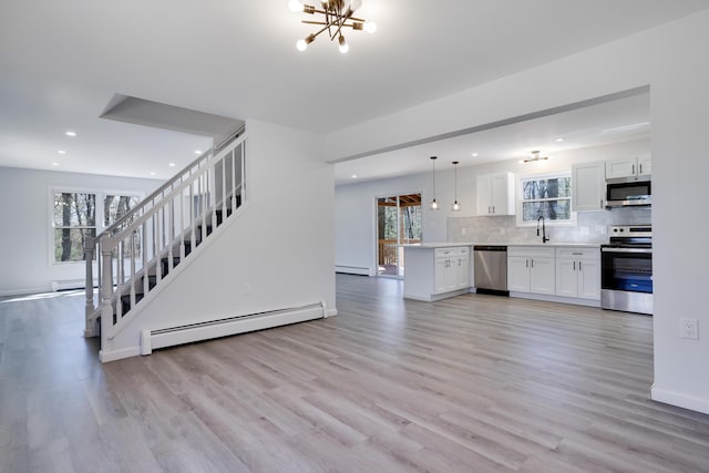 kitchen with stainless steel appliances, recessed lighting, a healthy amount of sunlight, and baseboard heating
