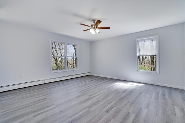 empty room with baseboards, a baseboard radiator, ceiling fan, and wood finished floors