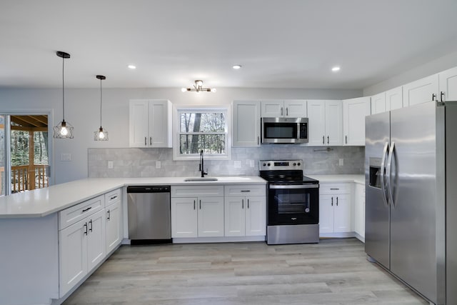 kitchen featuring a sink, appliances with stainless steel finishes, a peninsula, and a wealth of natural light
