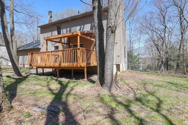 back of house featuring a deck and a chimney