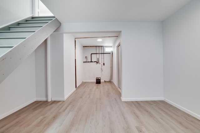 basement featuring baseboards and wood finished floors
