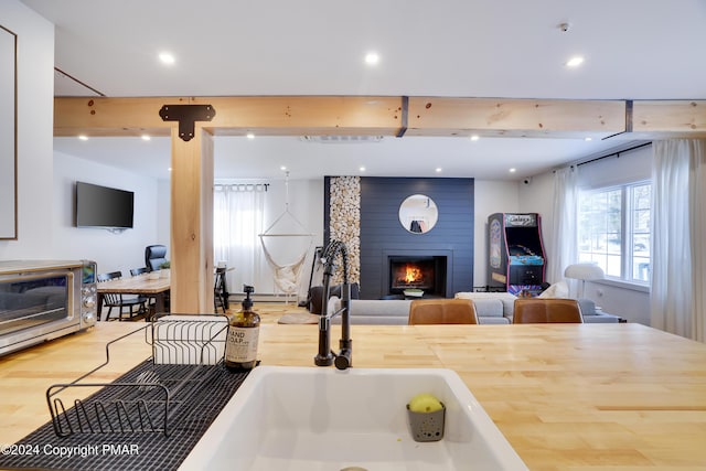 kitchen featuring light wood-style floors, a fireplace, open floor plan, and recessed lighting