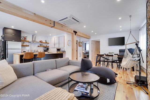 living area with light wood-type flooring, beamed ceiling, and recessed lighting