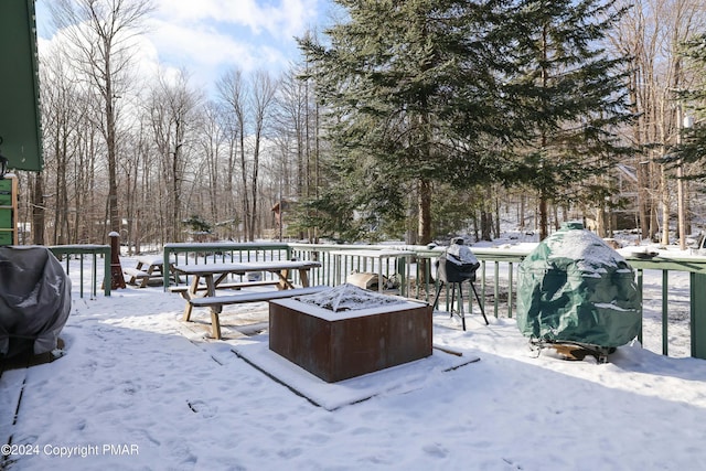 snow covered deck with an outdoor fire pit