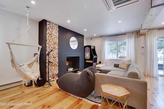 living room with a baseboard radiator, recessed lighting, visible vents, a large fireplace, and hardwood / wood-style flooring