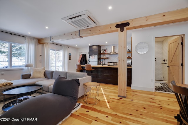 living area featuring a heating unit, light wood-type flooring, baseboards, and recessed lighting