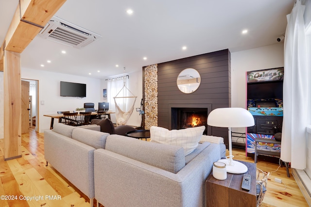 living room with a large fireplace, visible vents, light wood finished floors, and recessed lighting