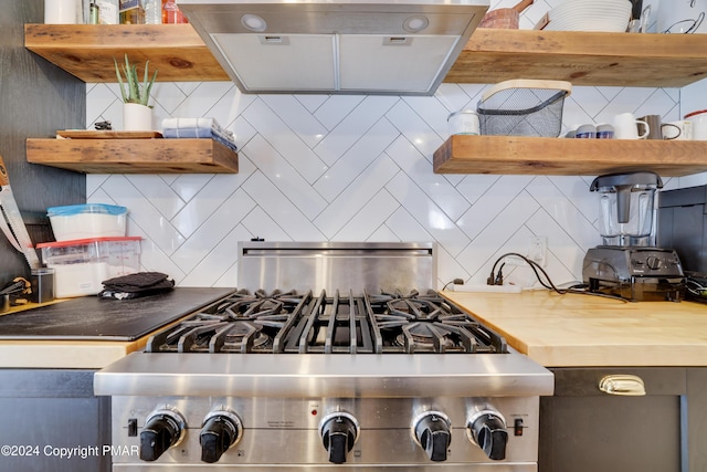 kitchen featuring tasteful backsplash, butcher block countertops, stove, and open shelves