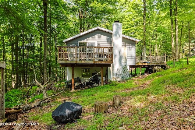 rear view of property with a chimney and a deck