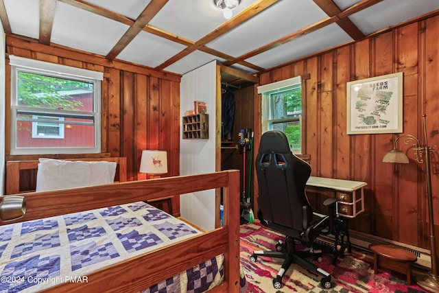 bedroom with coffered ceiling, multiple windows, and wood walls