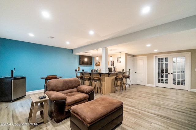 living area with recessed lighting, indoor wet bar, light wood-style flooring, and baseboards