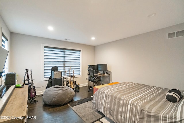 bedroom with multiple windows, visible vents, and wood finished floors