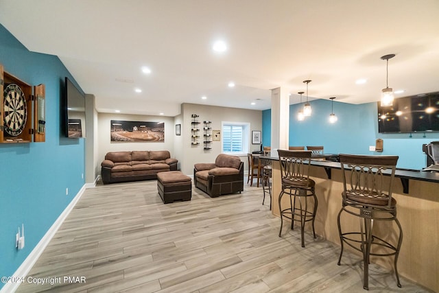 bar featuring baseboards, light wood-type flooring, decorative light fixtures, and recessed lighting