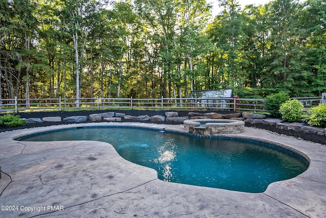 view of pool featuring a patio area, a fenced backyard, and a pool with connected hot tub