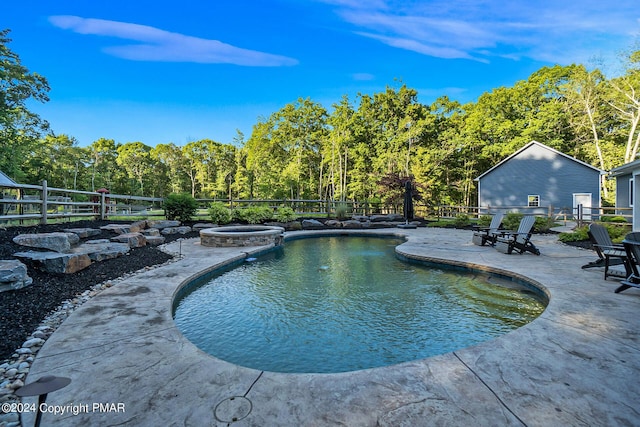 view of pool featuring a patio, fence, and a pool with connected hot tub