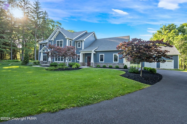 view of front of property with driveway, stone siding, and a front yard