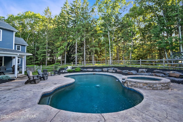 view of swimming pool featuring a pool with connected hot tub, a fenced backyard, and a patio