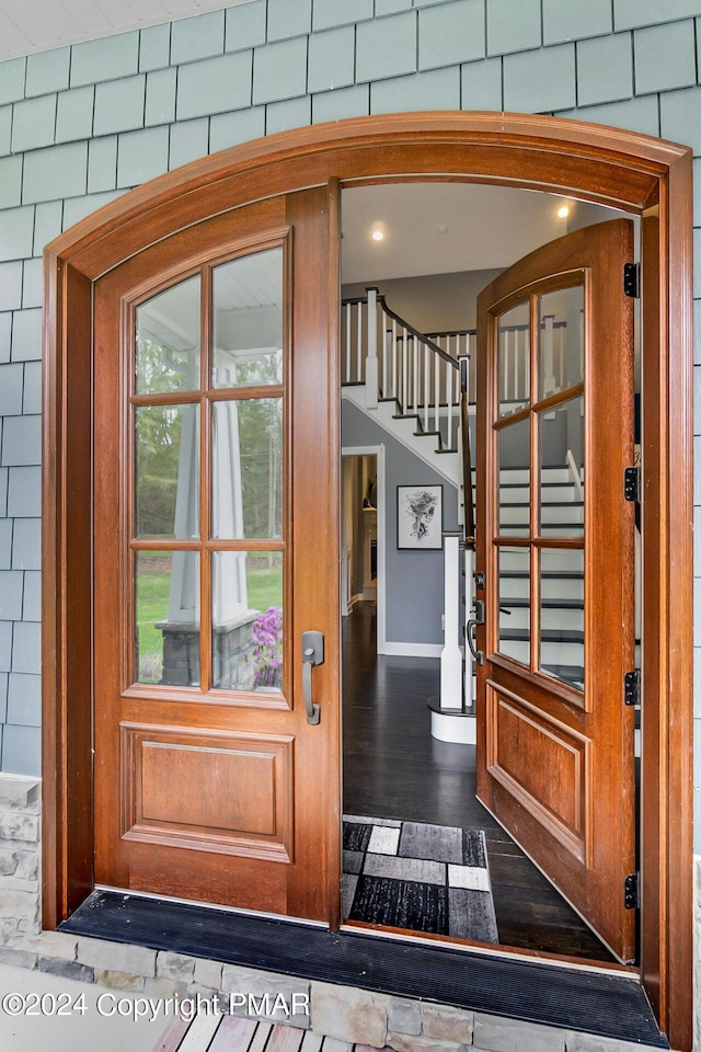 doorway to outside featuring dark wood-style floors and stairs