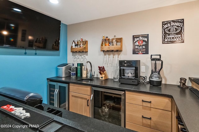 bar with beverage cooler, wet bar, and a sink