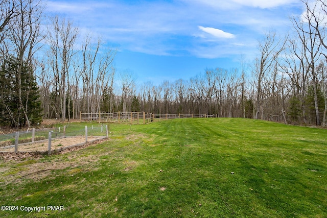 view of yard with fence and a view of trees