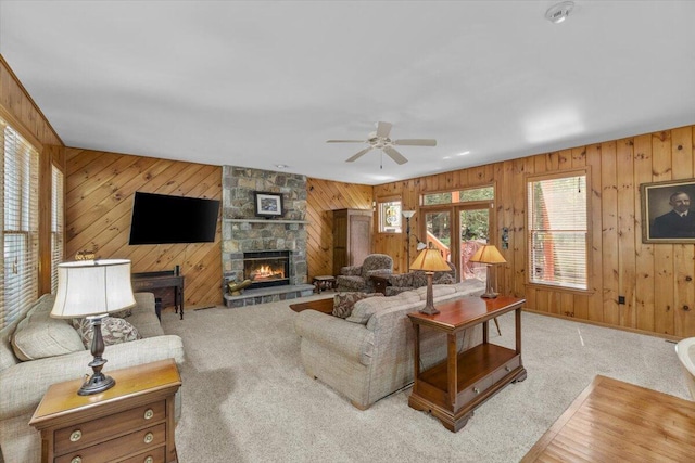 105 Waygood Way, Pocono Pines, PA 18350 - living room featuring wooden walls, plenty of natural light, ceiling fan, a stone fireplace, and carpet