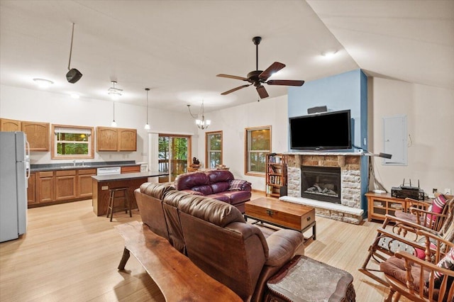 105 Waygood Way, Pocono Pines, PA 18350 - living area with light wood-style floors, ceiling fan, a fireplace, electric panel, and a chandelier
