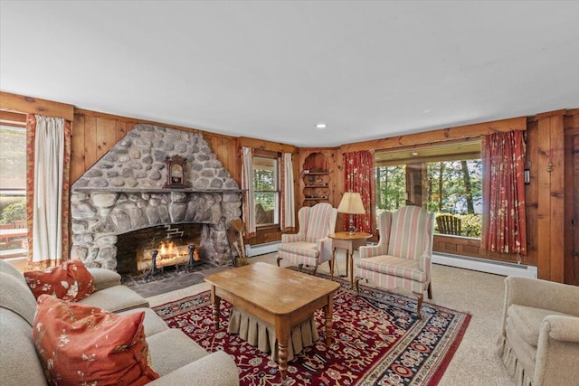 105 Waygood Way, Pocono Pines, PA 18350 - living area with a baseboard radiator, a stone fireplace, carpet, and wooden walls