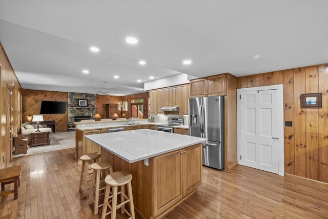 105 Waygood Way, Pocono Pines, PA 18350 - kitchen featuring stainless steel appliances, wood walls, a peninsula, light wood finished floors, and a center island