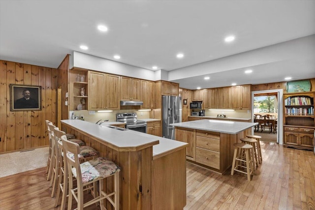 105 Waygood Way, Pocono Pines, PA 18350 - kitchen with appliances with stainless steel finishes, open shelves, a kitchen bar, wood walls, and under cabinet range hood