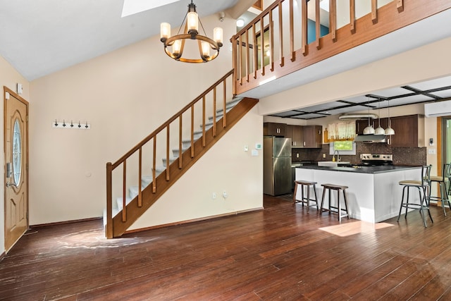 205 Victory Ln, Long Pond, PA 18334 - kitchen featuring appliances with stainless steel finishes, dark countertops, a sink, a chandelier, and a kitchen breakfast bar