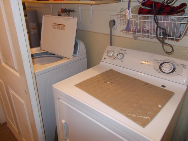 laundry room with laundry area, washer and clothes dryer, and electric water heater