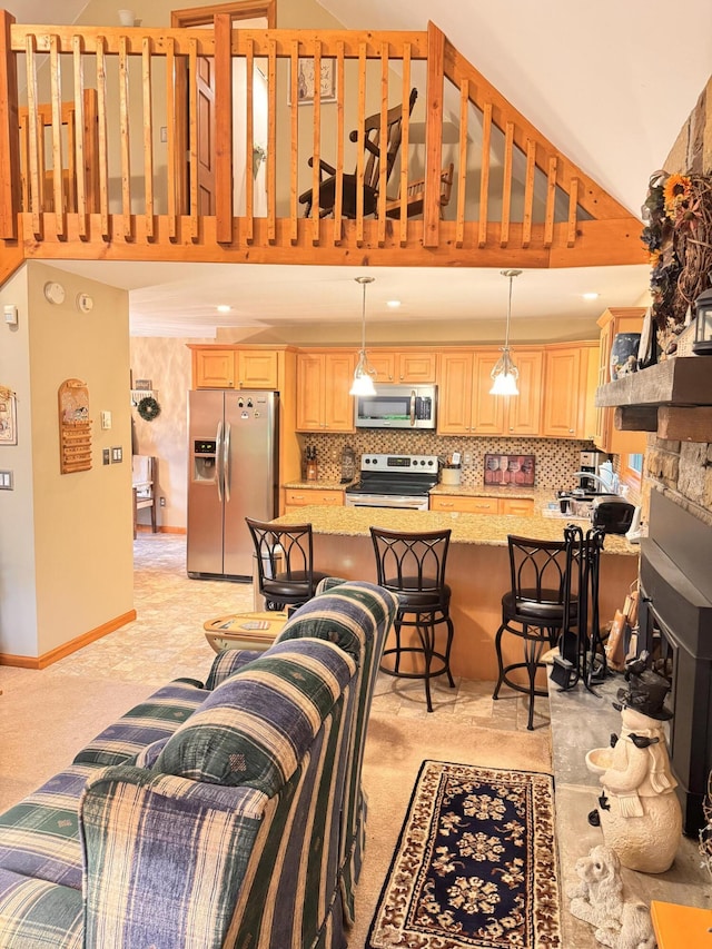 155 Clifton Dr, Bushkill, PA 18324 - kitchen featuring stainless steel appliances, a high ceiling, light brown cabinetry, a kitchen bar, and decorative backsplash