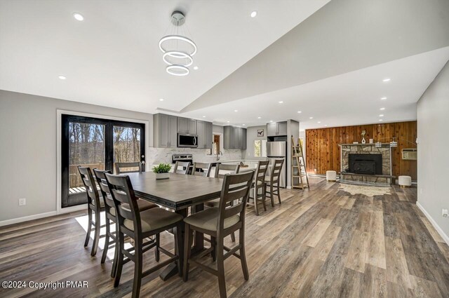 181 Williams Ln, Scotrun, PA 18355 - dining room with a fireplace, wood finished floors, vaulted ceiling, baseboards, and recessed lighting