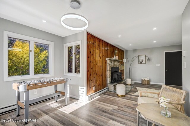 181 Williams Ln, Scotrun, PA 18355 - living area featuring a baseboard radiator, wood finished floors, a wood stove, recessed lighting, and baseboards