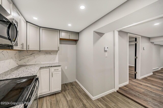 181 Williams Ln, Scotrun, PA 18355 - kitchen featuring appliances with stainless steel finishes, wood finished floors, light stone counters, tasteful backsplash, and recessed lighting