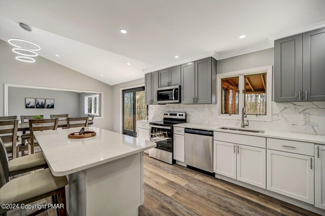181 Williams Ln, Scotrun, PA 18355 - kitchen with appliances with stainless steel finishes, a sink, a breakfast bar area, decorative backsplash, and vaulted ceiling