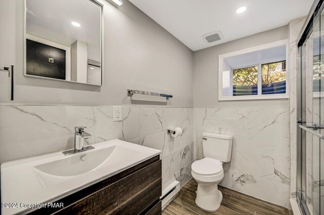 181 Williams Ln, Scotrun, PA 18355 - bathroom featuring tile walls, a shower stall, toilet, vanity, and a baseboard heating unit